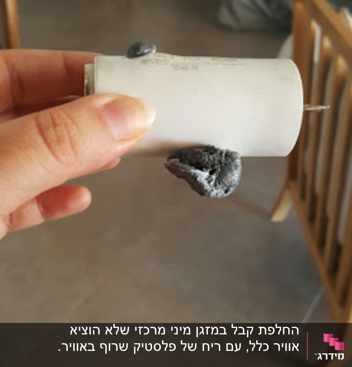 יד מחזיקה רכיב של מזגן עם חוטים חשופים